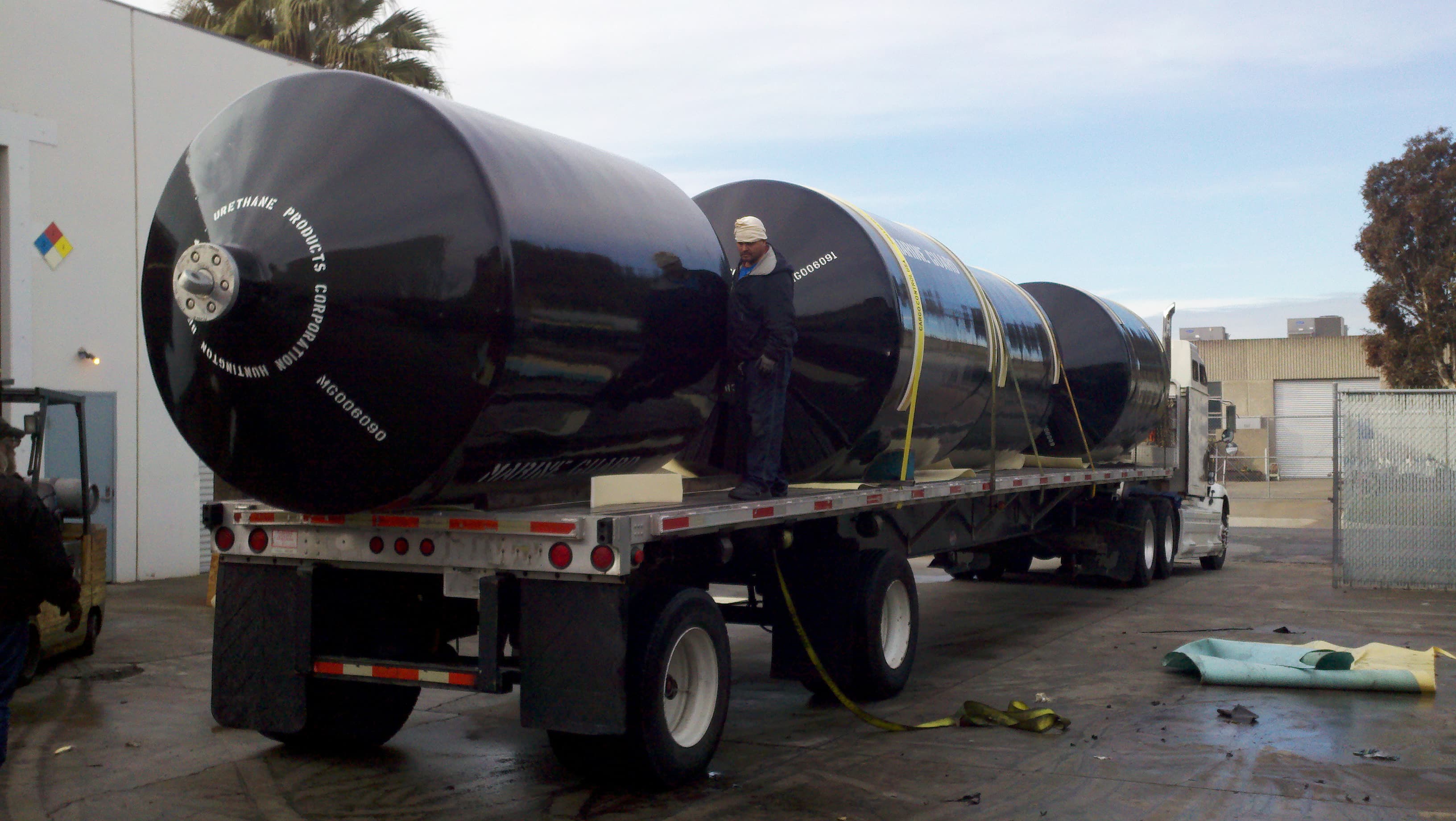 Steel coils and building materials secured on a flatbed trailer