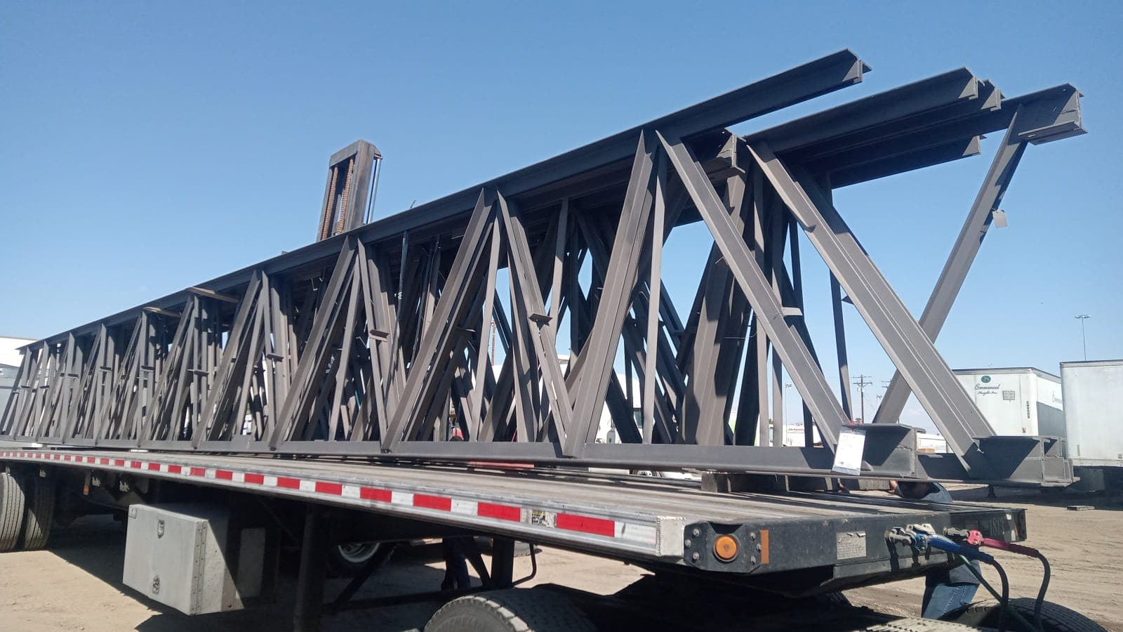 Extendable flatbed hauling long steel beams